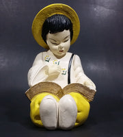 Vintage Chalkware Asian Child in Yellow Hat Sitting and Reading a Book Figurine - Treasure Valley Antiques & Collectibles