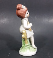 Vintage Victorian Girl Sitting on a Fence Playing a Mandolin Ceramic Figurine - Treasure Valley Antiques & Collectibles