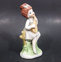 Vintage Victorian Girl Sitting on a Fence Playing a Mandolin Ceramic Figurine - Treasure Valley Antiques & Collectibles