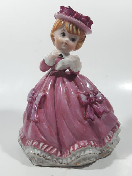 Vintage Girl in Pink Dress with Bows Wearing a Hat Holding Pen and Paper 7" Ceramic Wind Up Musical Figurine