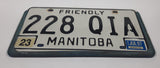1997 Friendly Manitoba White With Black Letters Metal Vehicle License Plate Tag 228 QIA in Blue Cluthe Frame Holder